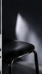 Black chair caught in a shaft of light